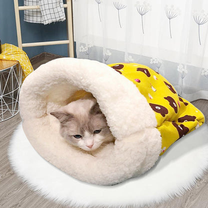 Cat resting inside a yellow cat sleeping bag with a cream-colored opening